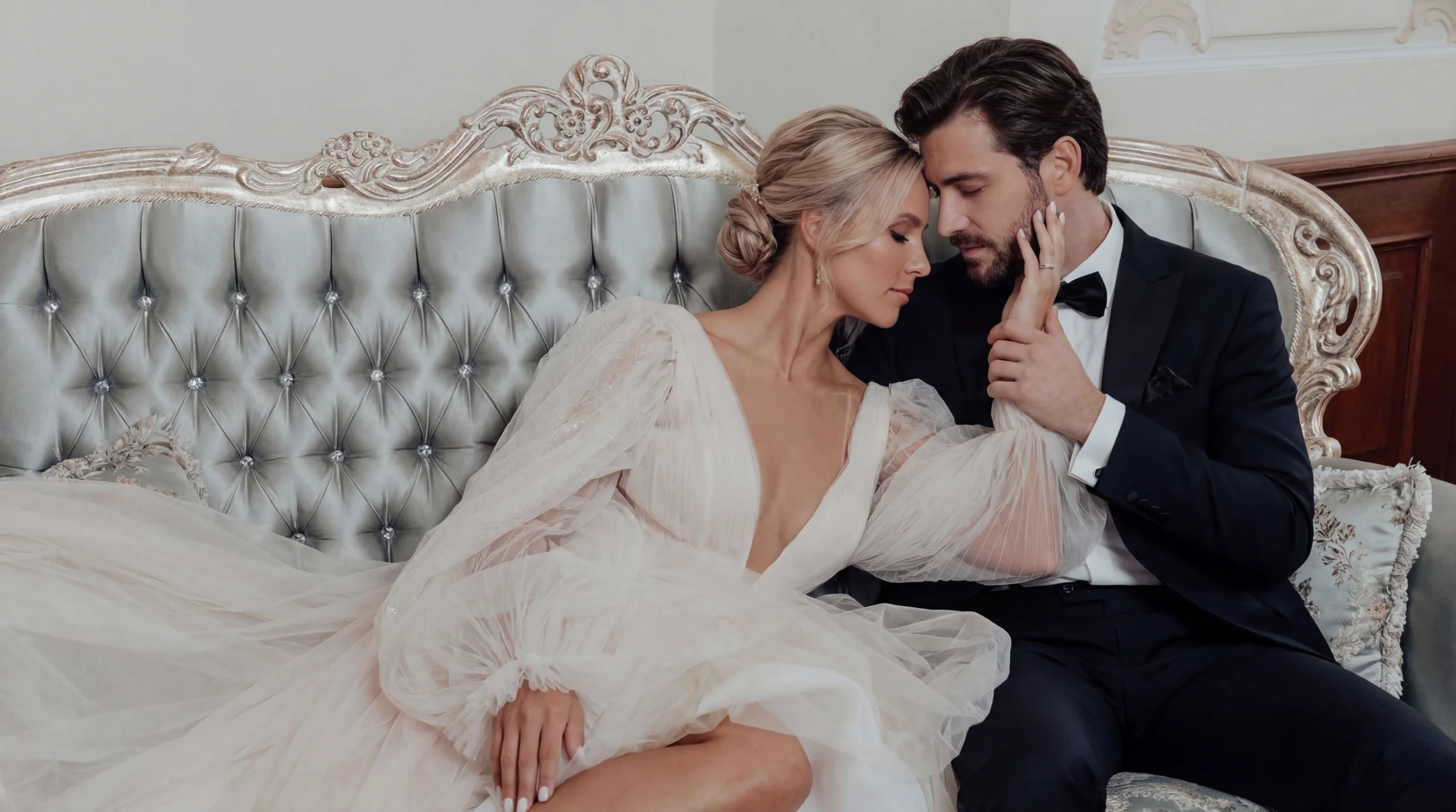 Elegantes Brautpaar auf einem Sofa bei einem romantischen Hochzeitsshooting von Swissvows Hochzeitsfotograf Zürich.